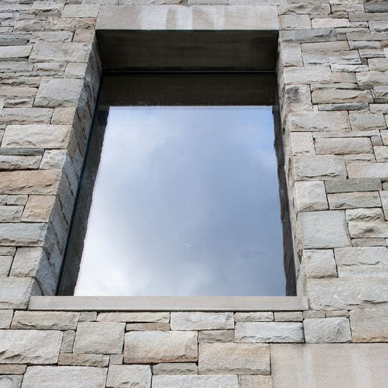 Rectangular window embedded in a stone wall completed using Blue Grey Sandstone Machined. 