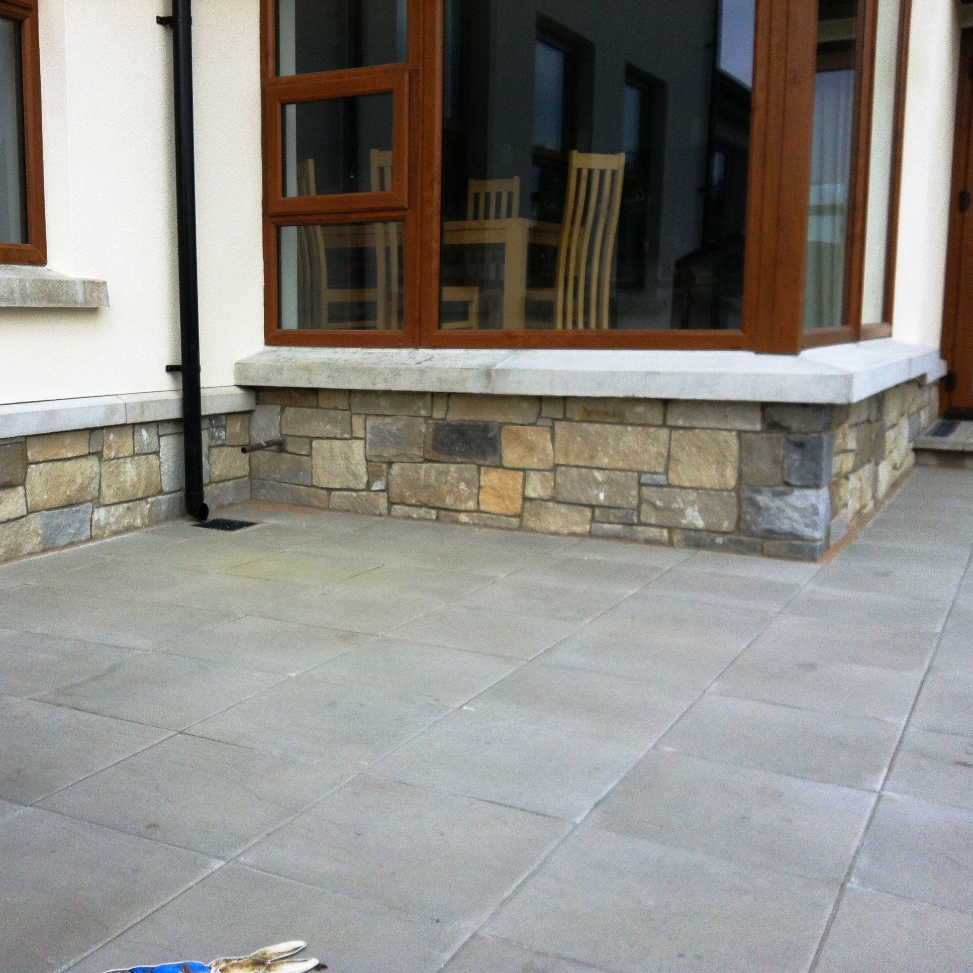 Low stone wall featuring a mix containing Blue Grey Sandstone Stoneer Cladding. 