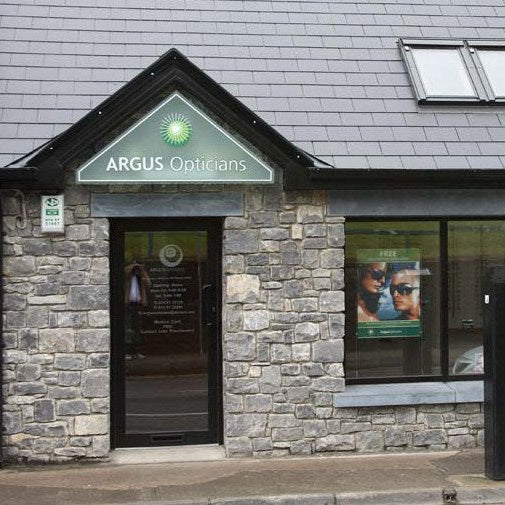 Building exterior with 'Argus Opticians' sign and bespoke blue limestone door lintel and window lintel. 