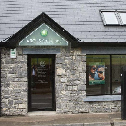 Building exterior with 'Argus Opticians' sign and bespoke blue limestone door lintel and window lintel. 