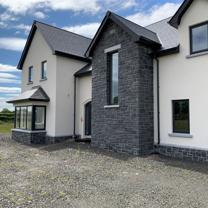 Modern house with stone façade featuring blue limestone window lintel and sills with a sanded finish.  