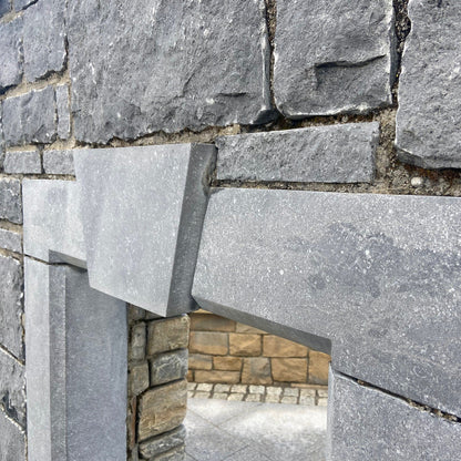Close-up of a stone wall with a blue limestone lintel and keystone detail. 