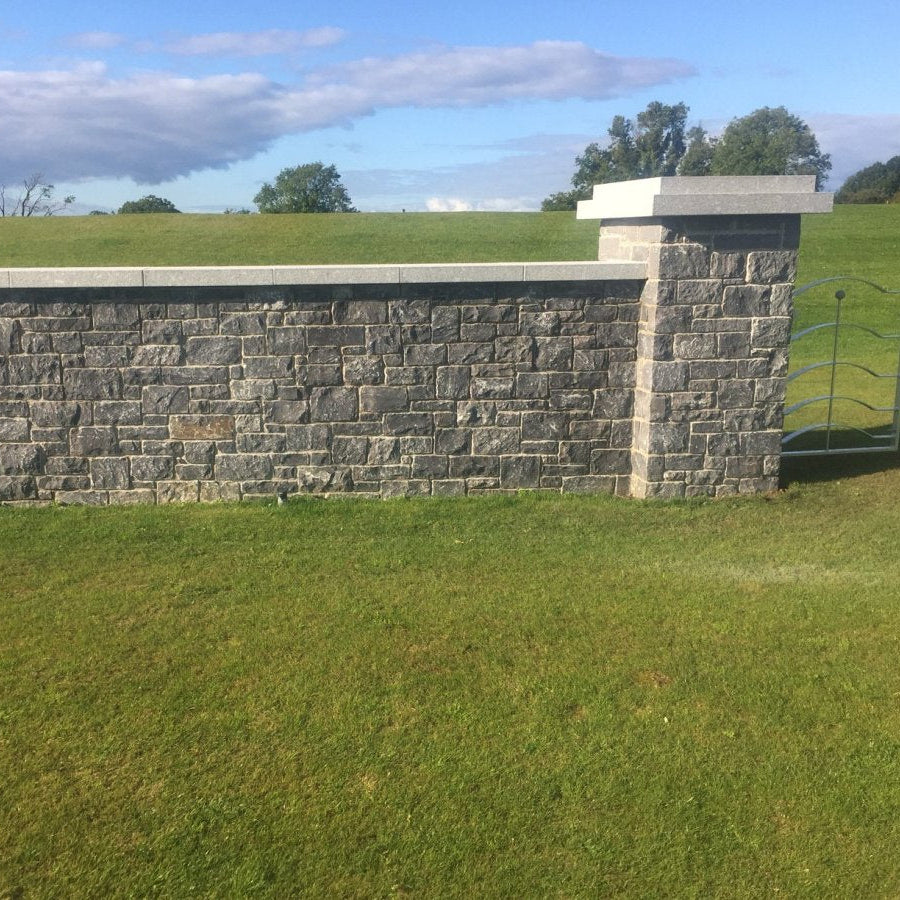 Boundary wall and pillar completed in blue limestone building stone and silver granite wall and pillar capping. 