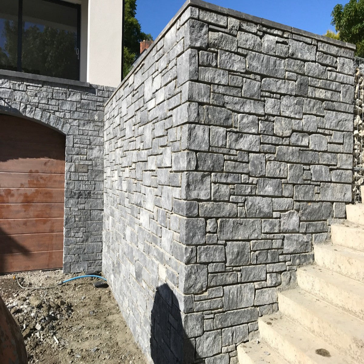 House under construction with stonework completed in Blue Limestone building stone. 
