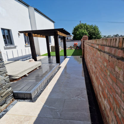 Patio area with hot tub featuring Blue Limestone Paving Cobbles bordering porcelain tiles. 