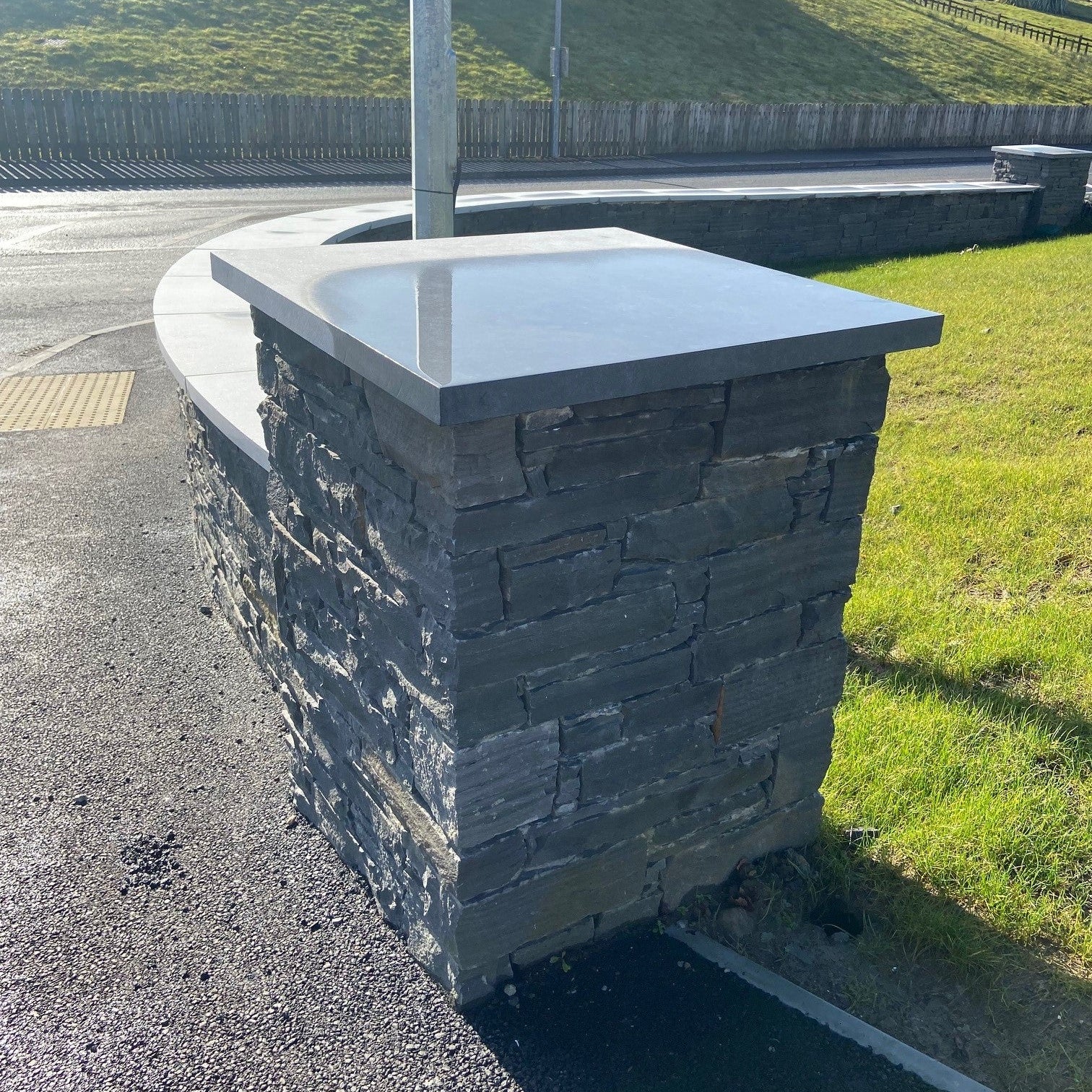 Stone wall with a bespoke flat limestone wall cap in an outdoor setting
