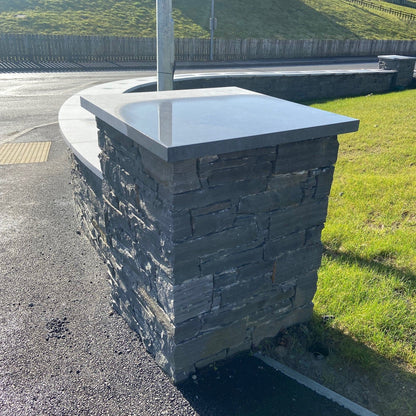 Stone wall with a bespoke flat limestone wall cap in an outdoor setting