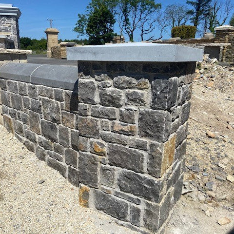 Stone wall with a bespoke blue limestone flat pier cap on display at McMonagle Stone. 