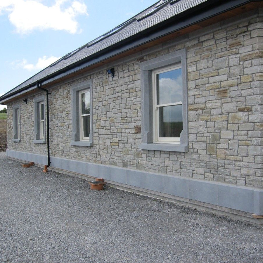Stone house with bespoke blue limestone window surrounds and plinths. 