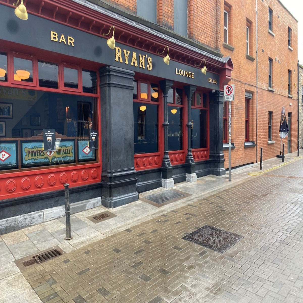Pub exterior with 'Ryan's' sign on a brick building. Features bespoke blue limestone dark honed plinths. 