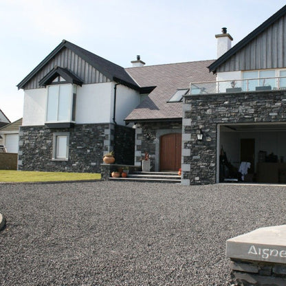 Modern house with bespoke blue limestone quoins, surrounds and pillar caps. 