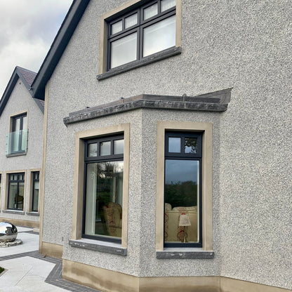 House exterior with modern windows and bespoke blue limestone sills with a rockfaced finish. 