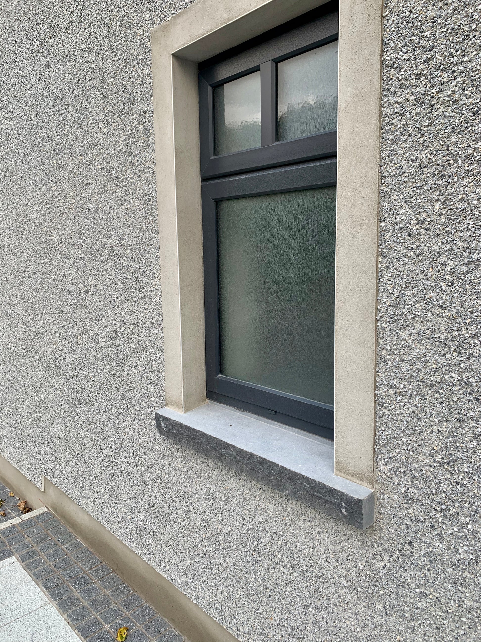 Window with bespoke Blue Limestone Sill with a rockfaced edge. 