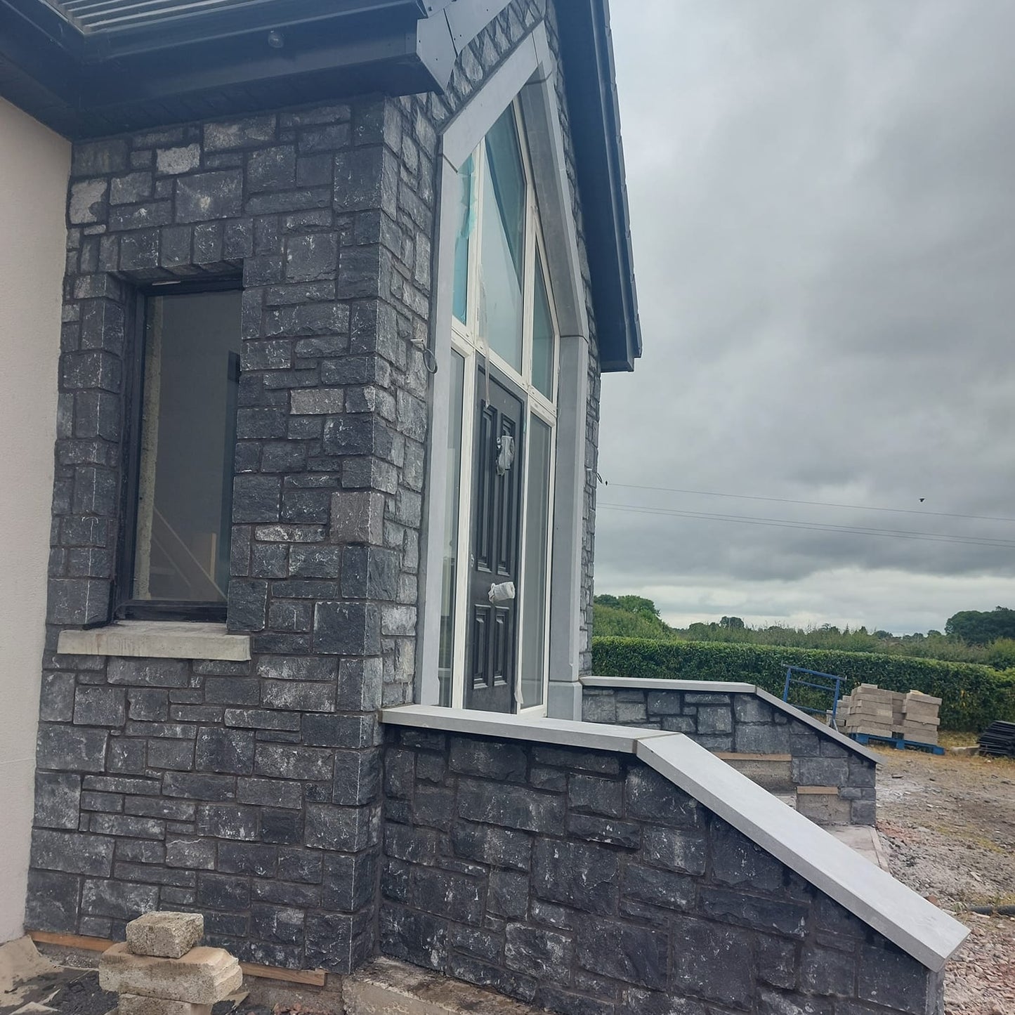 New build with entrance walls cladded in Blue Limestone Stoneer Cladding.