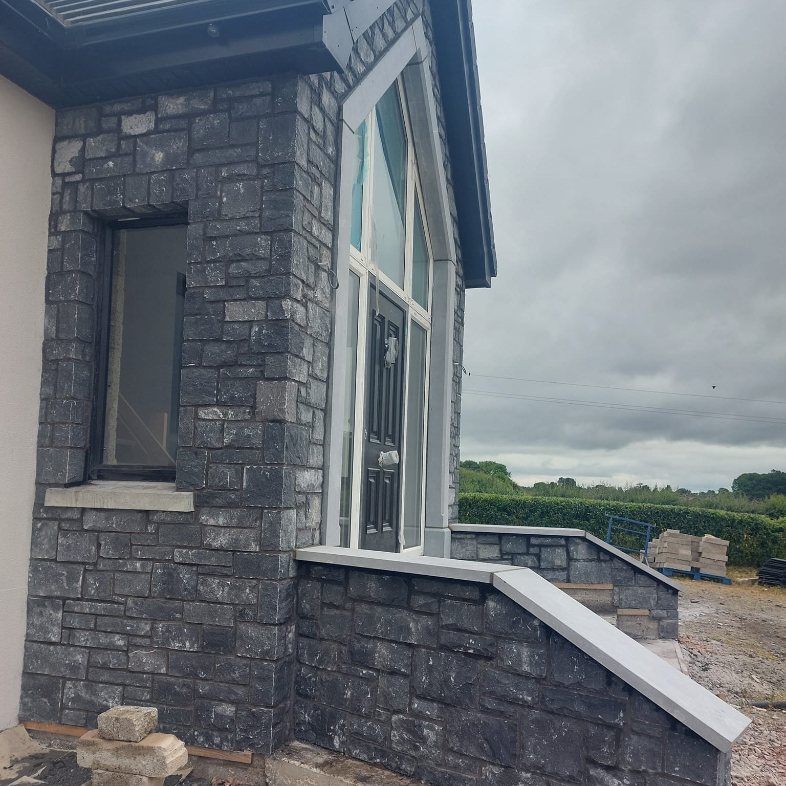 New build with entrance walls cladded in Blue Limestone Stoneer Cladding.