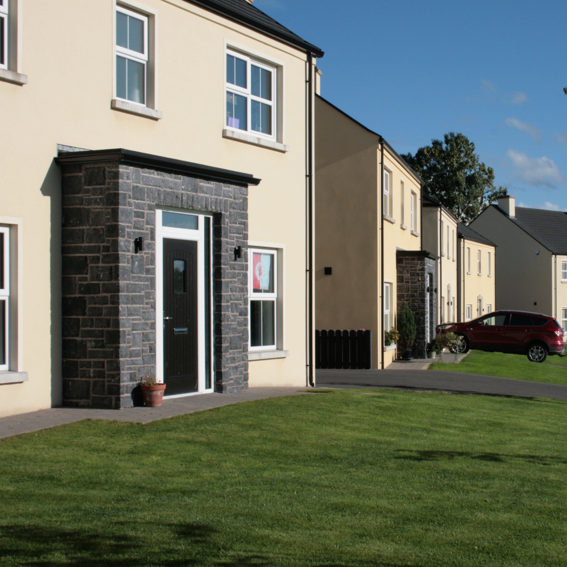Housing estate with decorative stone porch cladded Blue Limestone Stoneer Cladding. 