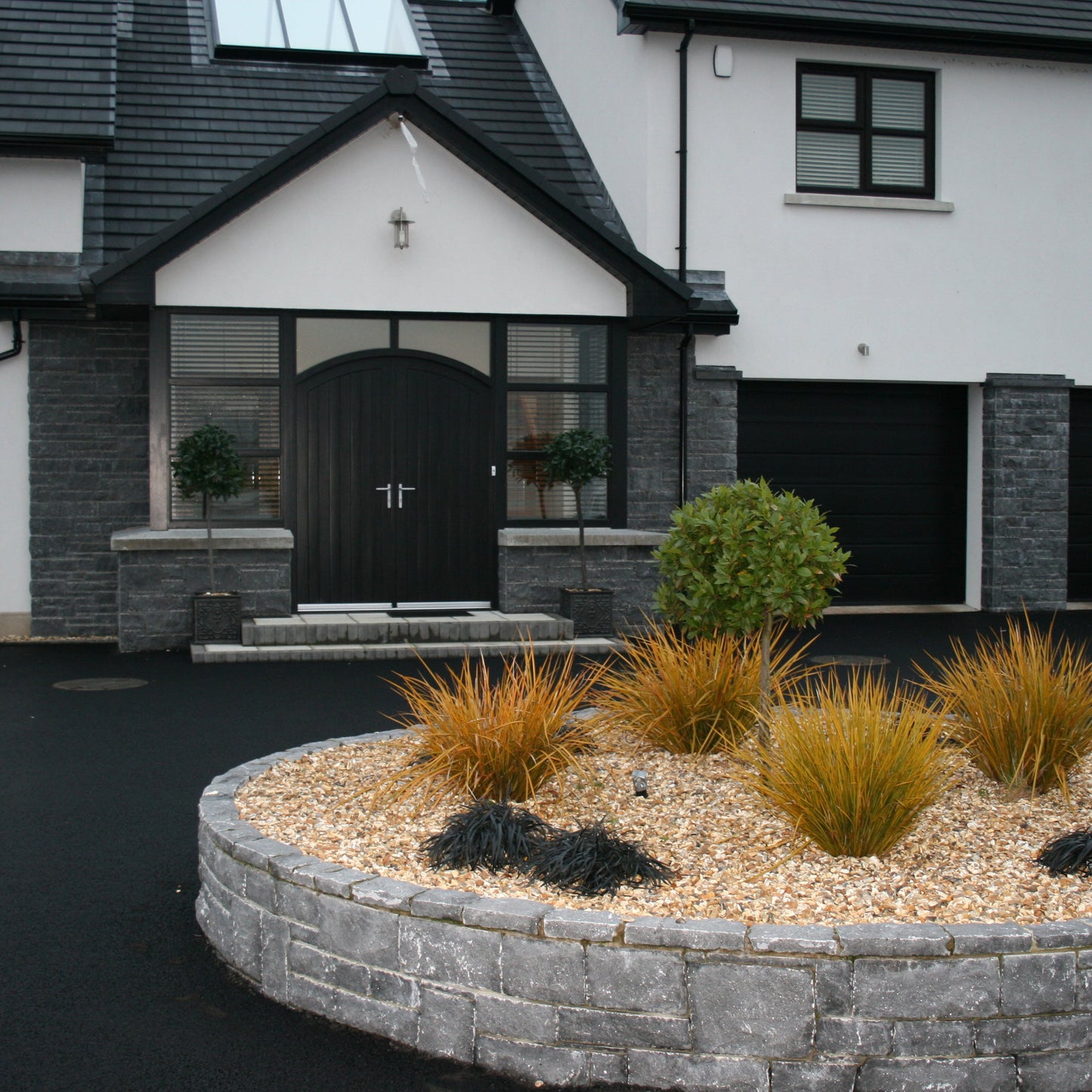 Contemporary home with stone feature walls and driveway garden wall cladded in Blue Limestone Stoneer Cladding.