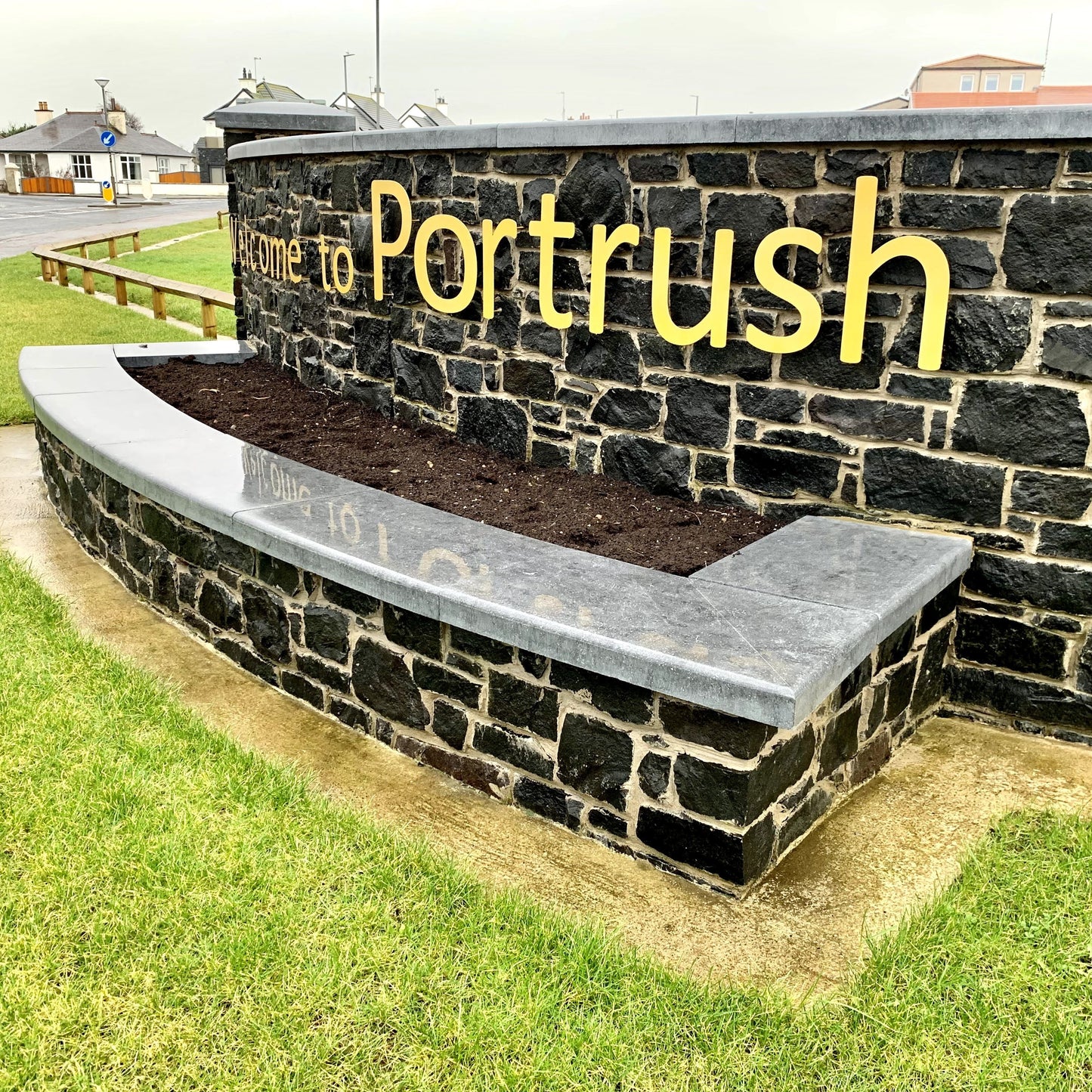 Portrush boundary wall with raised planter completed with bespoke blue limestone wall capping. 