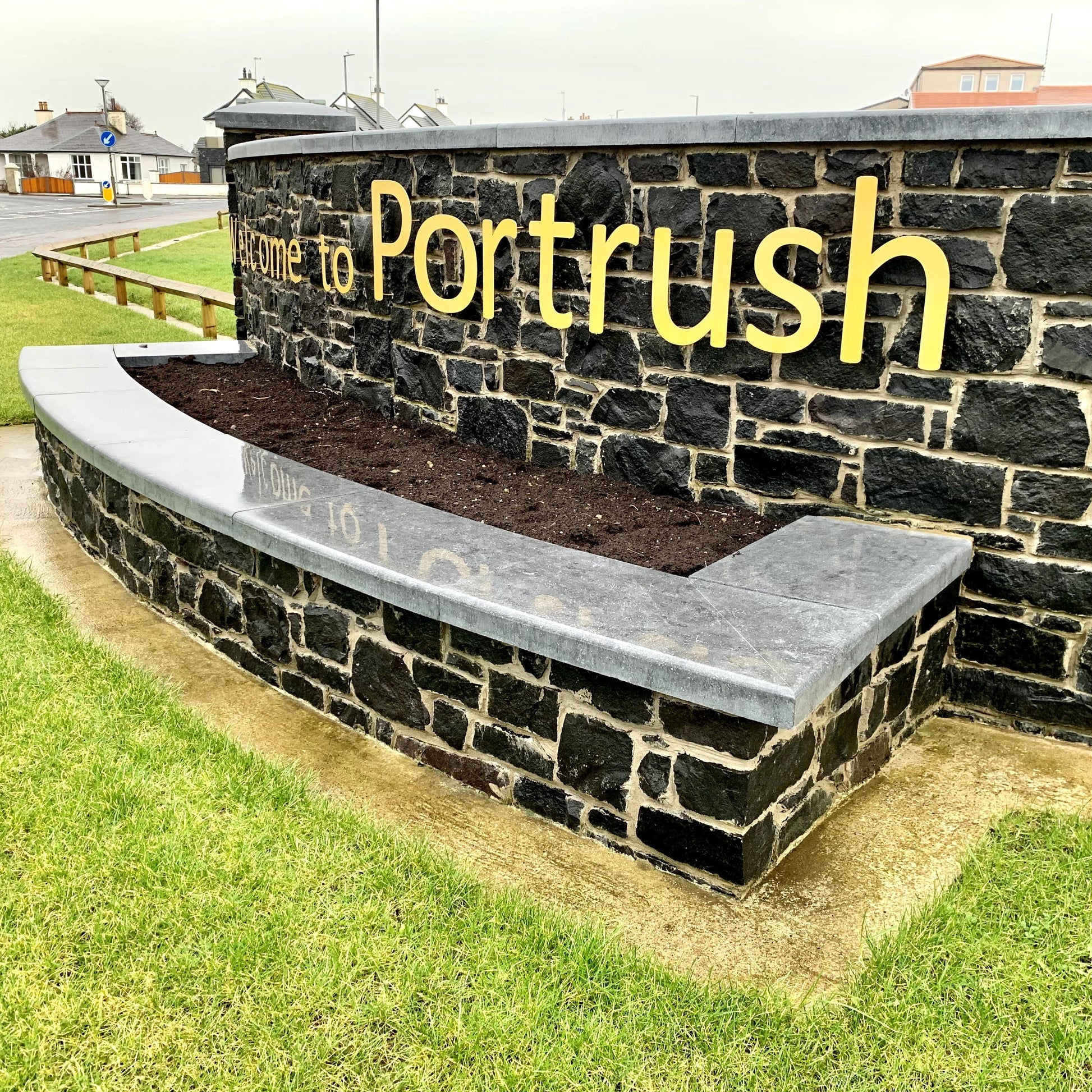 Portrush boundary wall with raised planter completed with bespoke blue limestone wall capping. 