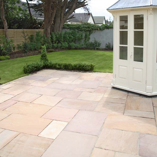 Patio with garden and white shed. Paving is Camel Dust Sandstone Patio Packs.