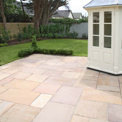 Patio with garden and white shed. Paving is Camel Dust Sandstone Patio Packs.