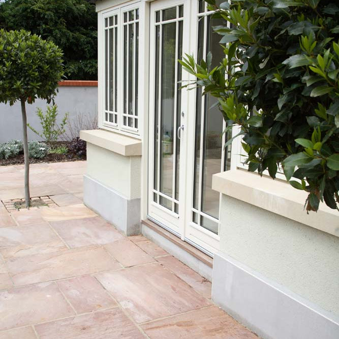 Sunroom doors leading out to patio area completed using Camel Dust Sandstone Paving. 
