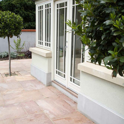 Sunroom doors leading out to patio area completed using Camel Dust Sandstone Paving. 