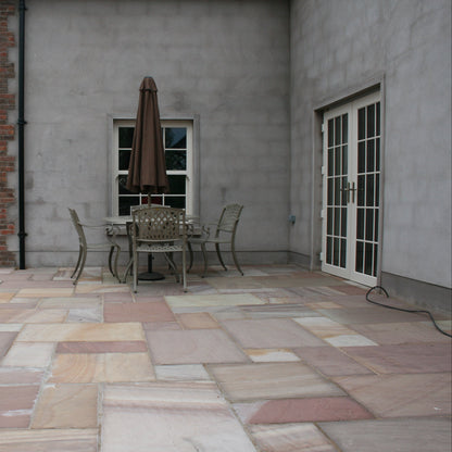 Patio area with garden table and chairs. Paving completed using Camel Dust Sandstone Patio Packs. 