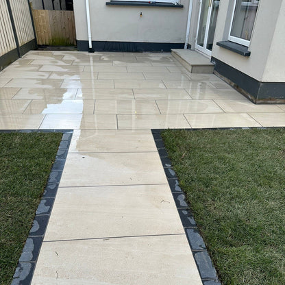 Small patio area featuring Camel Jewel Range Porcelain Paving Tiles with a black cobble border. 