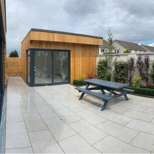 An outdoor patio installation of Camel porcelain paving tiles in a garden setting. 