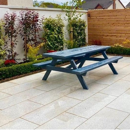 Patio with picnic bench and planting and wooden fence in the background. Paving is Camel Jewel Range Porcelain Paving Tiles. 