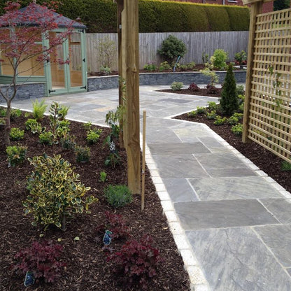 Garden pathway with a wooden pergola and landscaped area. Paving completed using Cider Black Sandstone Patio Packs.