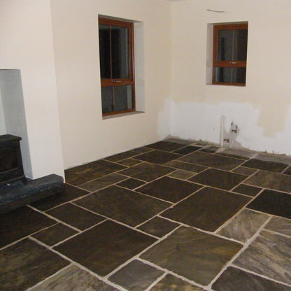 Internal living room floor completed using Cider Black Sandstone paving. 