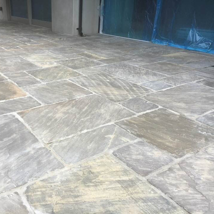 Close up of a new patio area finished using Cider Black Sandstone Paving in mixed patio pack sizes. 
