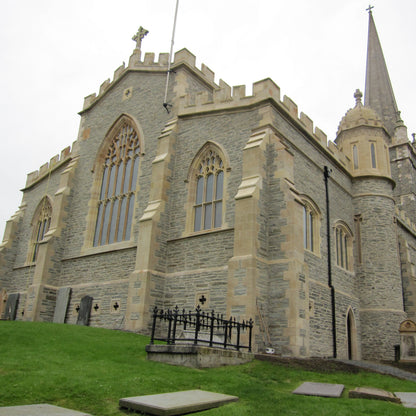 Large stone church with a prominent steeple on a cloudy day. Large architectural window surrounds completed using Clipsham Limestone. 