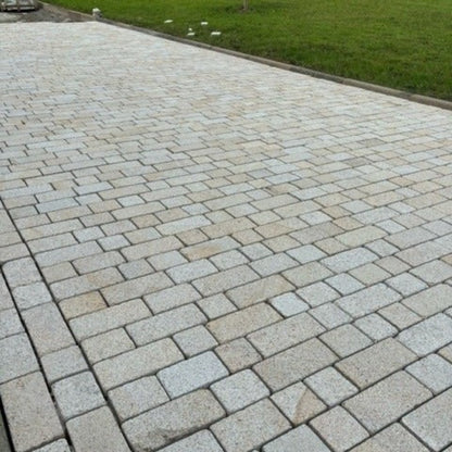A pathway laid out with Coachman's Gold Granite Paving Setts, showing a contemporary look with a bush hammered surface finish and tumbled edges.