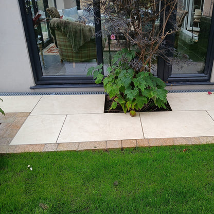 Modern pathway with tree in the centre completed using Coachman's Gold Granite Paving Setts as edging between paving and grass. 