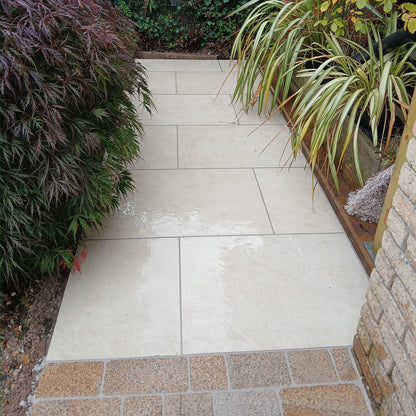 Modern pathway with planting on either side featuring Coachman's Gold Granite Paving Setts.