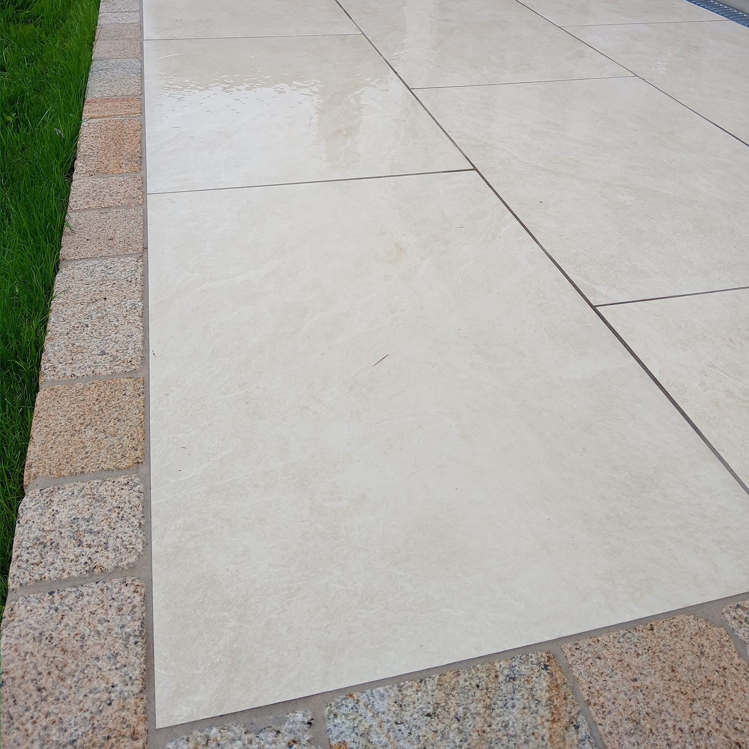 Close up of porcelain paving and Coachman's Gold Granite Paving Setts. 