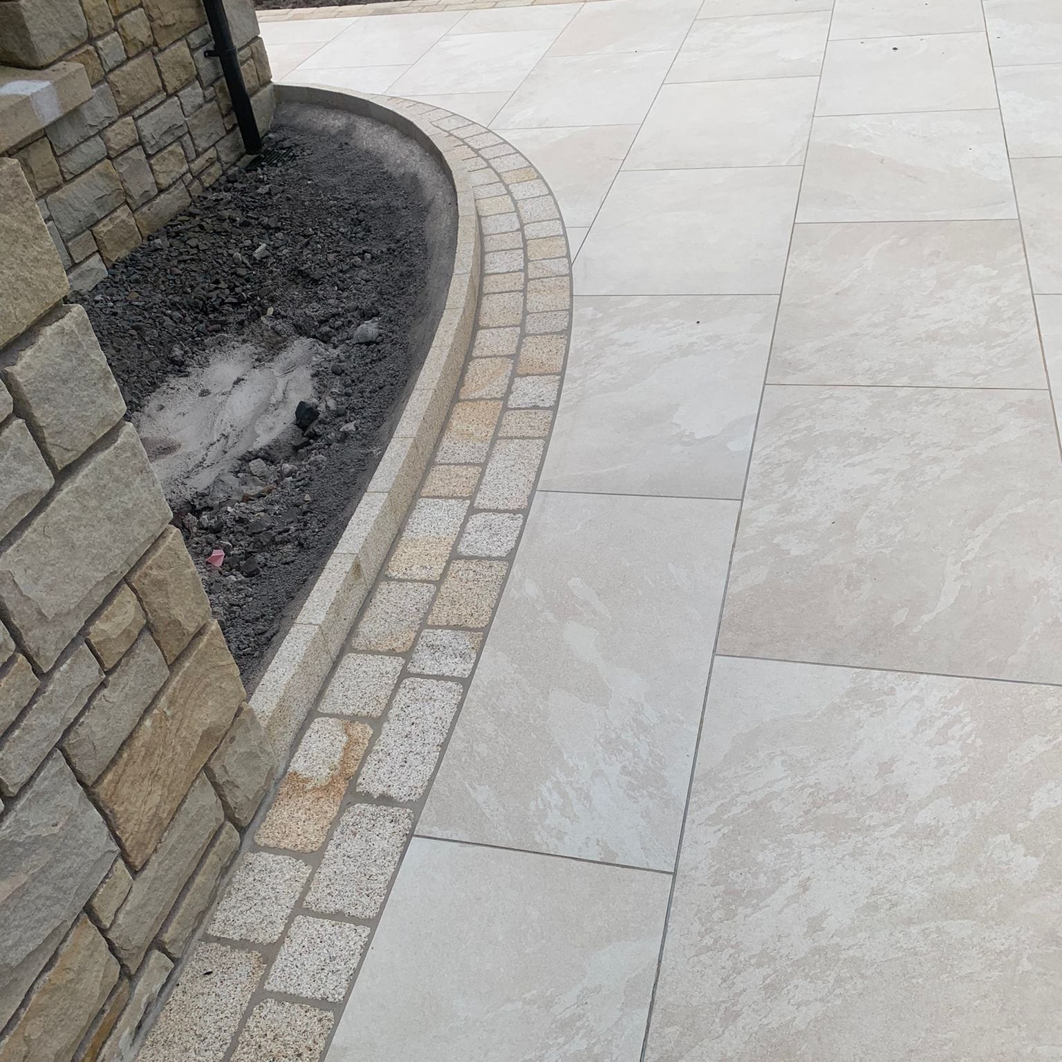 Patio edging featuring Coachman's Gold Granite Paving Setts. 