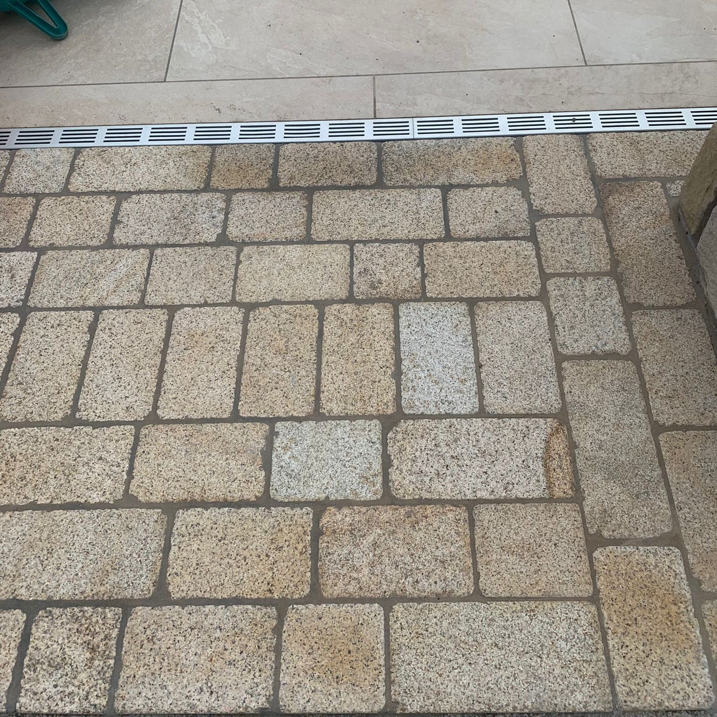 Patio area featuring Coachman's Gold Granite Paving Setts, showing a contemporary look with a bush hammered surface finish and tumbled edges.