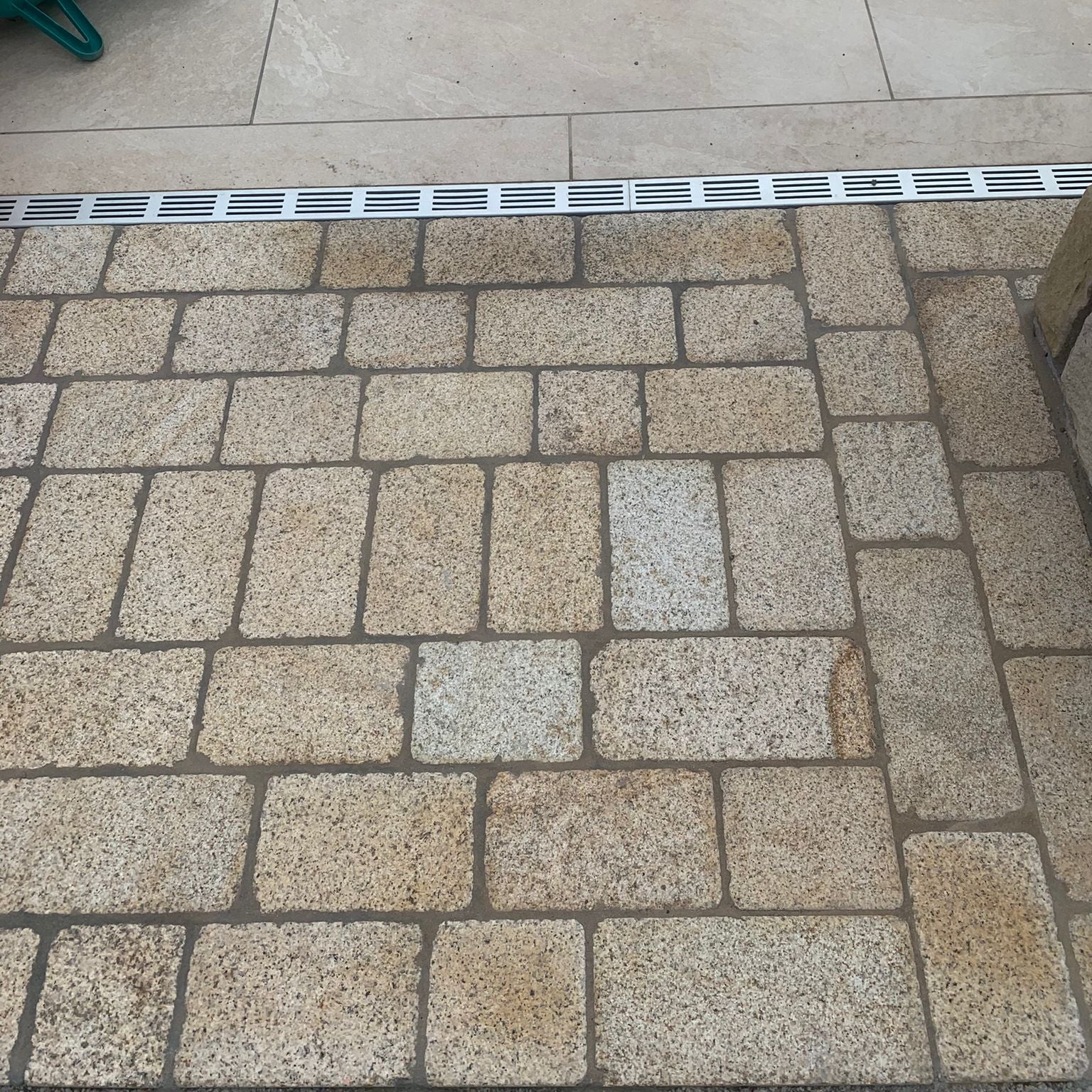Patio area featuring Coachman's Gold Granite Paving Setts, showing a contemporary look with a bush hammered surface finish and tumbled edges.