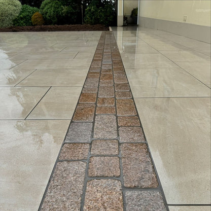 Porcelain patio with edging in Coachman's Gold Granite Paving Setts, showing a contemporary look with a bush hammered surface finish and tumbled edges.