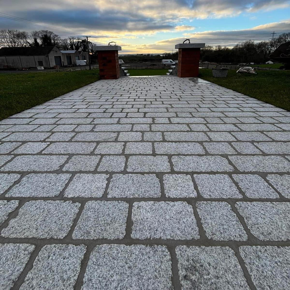 Paved pathway featuring Silver Granite Paving Setts leading to steps with a cloudy sky above