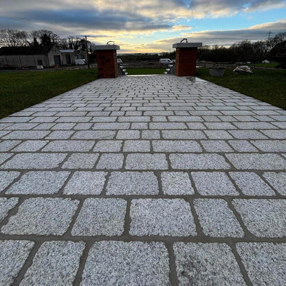 Paved pathway featuring Silver Granite Paving Setts leading to steps with a cloudy sky above