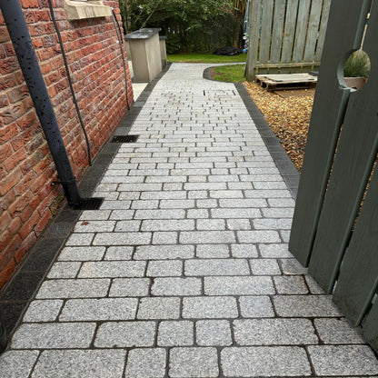 A pathway laid out with Coachman's Silver Granite Paving Setts, showing a contemporary look with a sawn surface finish and tumbled edges.