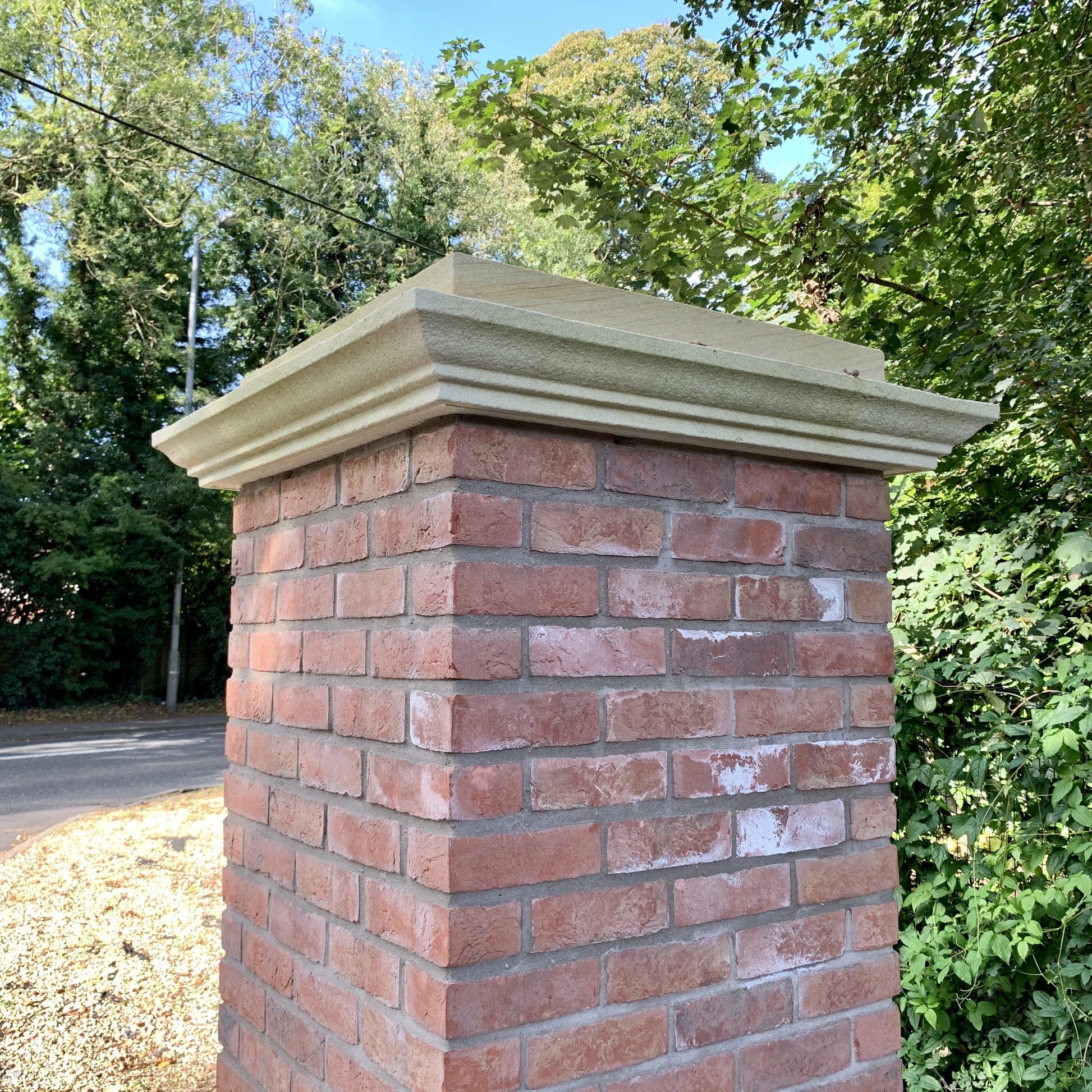 Red brick pillar with bespoke cream sandstone pier cap and a blasted finish. 