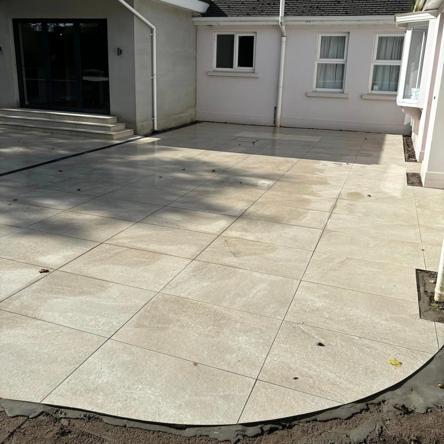 Patio area under construction using Cream Twice Qz Range Porcelain Paving Tiles. 
