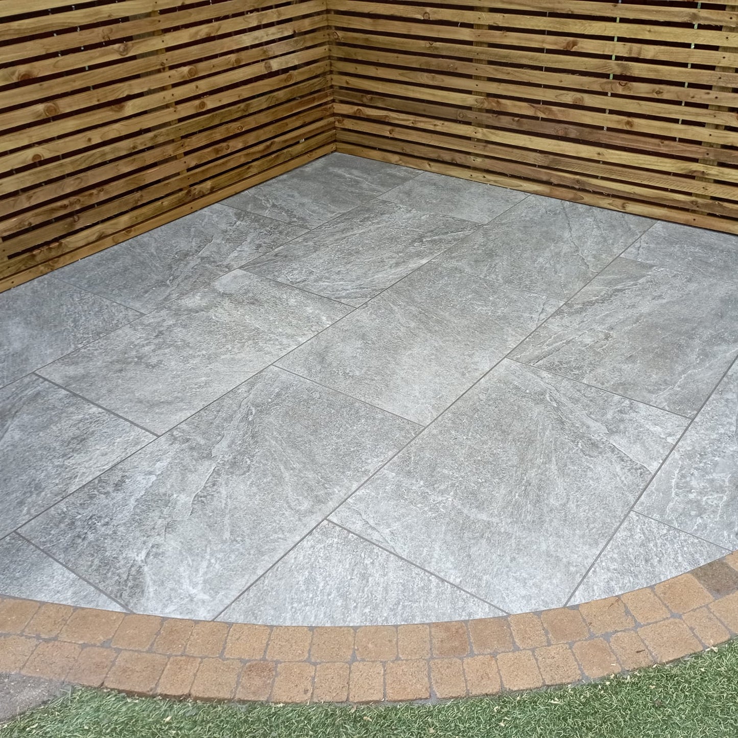 Small patio area featuring Dark Twice Qz Range Porcelain Paving Tiles. 
