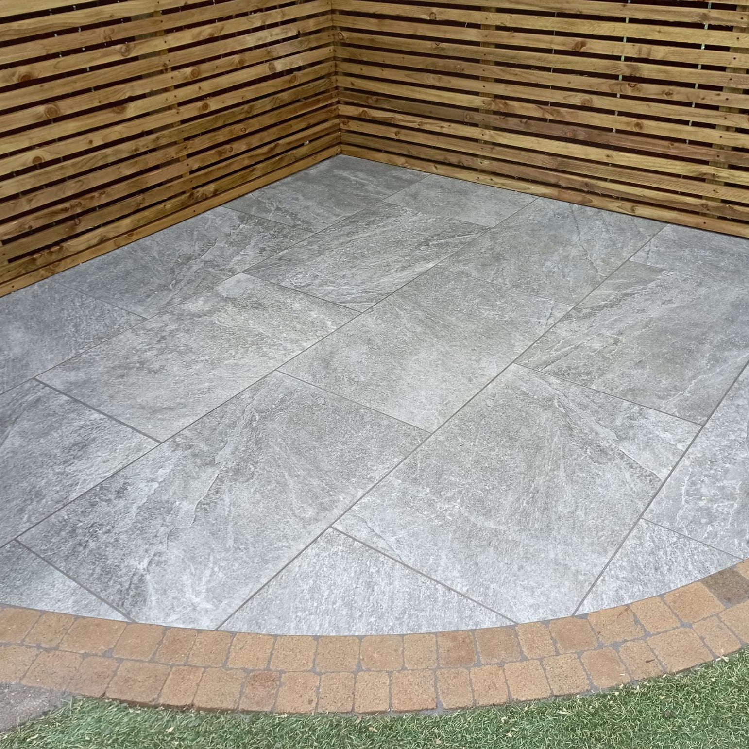 Small patio area featuring Dark Twice Qz Range Porcelain Paving Tiles. 